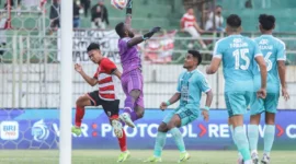 Pemain Madura United, Iran (kiri), berebut bola di udara dengan kiper PSBS Biak, Jhon Rericnal Pigai, pada laga BRI Liga 1 di Stadion Gelora Bangkalan. (Foto: ANTARA)