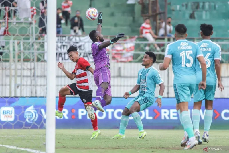 Pemain Madura United, Iran (kiri), berebut bola di udara dengan kiper PSBS Biak, Jhon Rericnal Pigai, pada laga BRI Liga 1 di Stadion Gelora Bangkalan. (Foto: ANTARA)