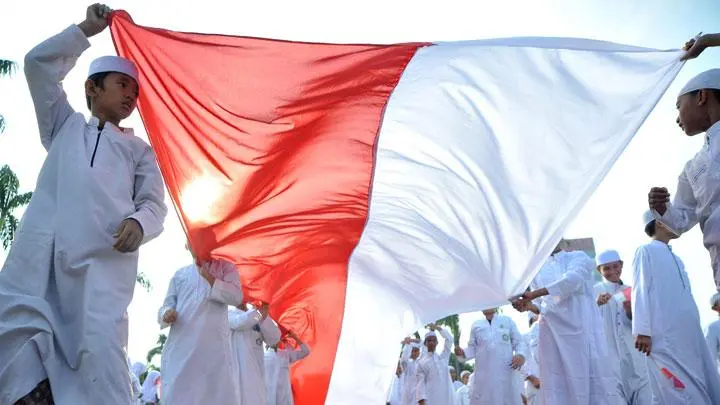 Santri membentangkan bendera Merah Putih saat kirab memperingati Hari Santri Nasional. Foto: ANTARA